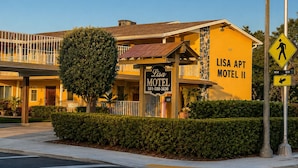 A motel with a sign reading 'Lisa APT Motel II' and a pedestrian crossing sign. - LISA MOTEL (Lake Worth Beach)