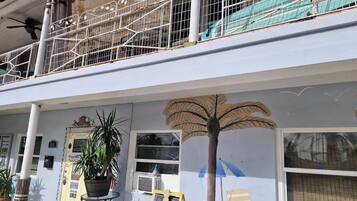 A building with a balcony, a palm tree mural, and a sign for cottage rentals.