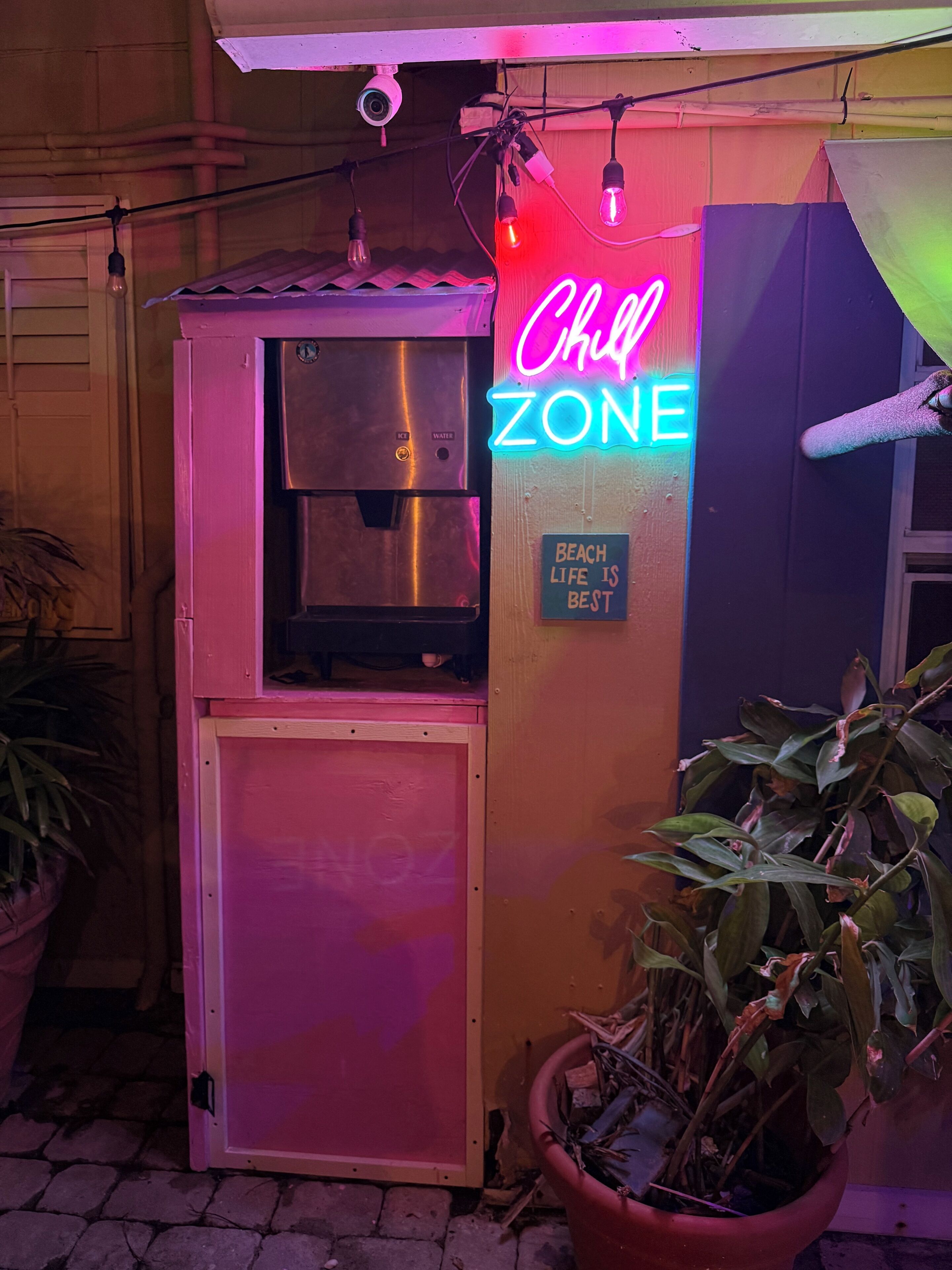 A neon sign reading 'Chill Zone' with a small sign below stating 'Beach life is best.'