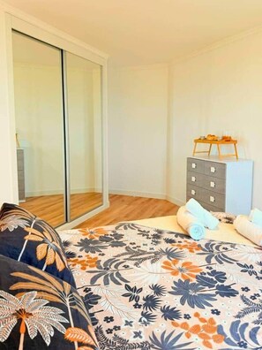 A bedroom with a bed, a dresser, and a sliding glass door. - Madeira Sea Escape by Stayguest (Caniço)