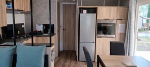 Pieni, käytännöllinen keittiö, jossa on jääkaappi, uuni ja pesuallas.