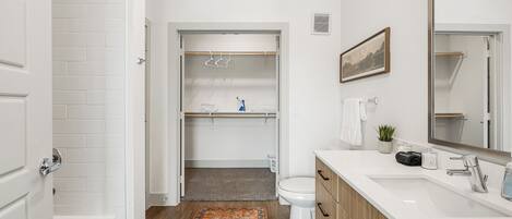 A bathroom with a bathtub, toilet, and a vanity with a mirror.