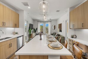 Una cocina moderna con una isla central, armarios de madera y un comedor con vistas.