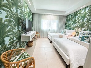 A hotel room with a bed, a sofa, a TV, a desk, and a chair. - Luxury Villa | Casa WED | Bahia Beach PR (Rio Grande)