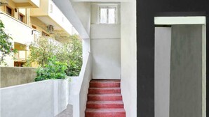 Eine Treppe mit roten, gemusterten Stufen, die zu einer Zwischenebene führt.