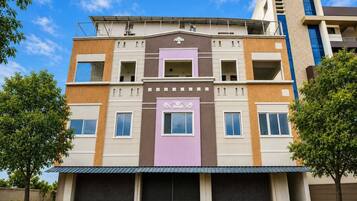 Un edificio de varios pisos con entrada central, varias ventanas y techo plano.