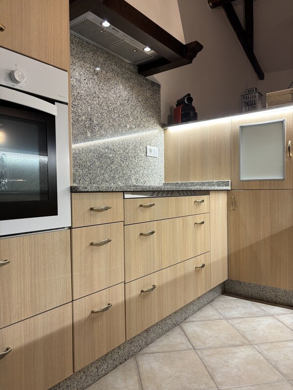 A kitchen with granite countertops, wooden cabinets, and a built-in oven.