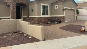 A residential house with a stone facade, a garage, and a landscaped front yard. - Beautiful, furnished single level home Great for travel Nurse/corp. housing 55+ (Mesa)