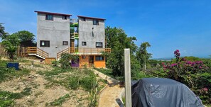 Ein zweistöckiges Gebäude mit Betonfassade, Holzgeländern und einem kleinen Eingang.
