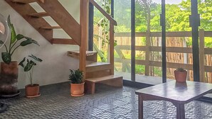 Um quarto com escada, janelas amplas e plantas em vasos.
