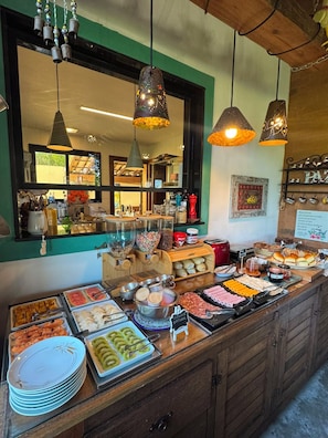 A buffet counter with various food items and a view of the kitchen area.