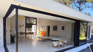 Ein modernes Haus mit Essbereich, Küche und Wohnraum mit großem Fenster.