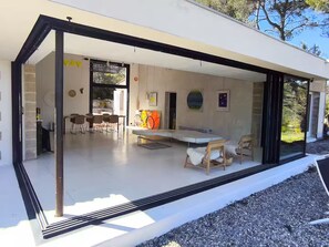 A modern house with a dining area, a kitchen, and a living space with a large window. - Villa Cézanne Panorama, Downtown Within Walking Distance (Aix-en-Provence)