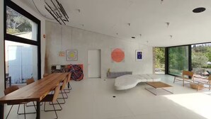 Ein modernes Interieur mit Essbereich, Sitzgelegenheiten und Kunstwerken.