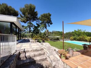 A modern outdoor area with a swimming pool, stone steps, and a patio with potted plants. - Villa Cézanne Panorama, Downtown Within Walking Distance (Aix-en-Provence)