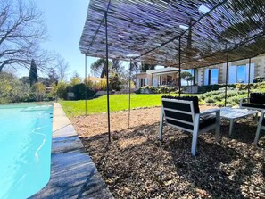 A poolside area with a pergola, seating, and a view of a house. - Villa Cézanne Panorama, Downtown Within Walking Distance (Aix-en-Provence)