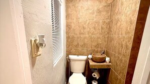 A compact bathroom with a toilet, a sink, and a shower area. - Studio. Independent entrance, AC, internet. (Miami)