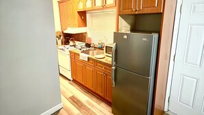 A kitchen with wooden cabinets, a stainless steel refrigerator, and a microwave. - Studio. Independent entrance, AC, internet. (Miami)