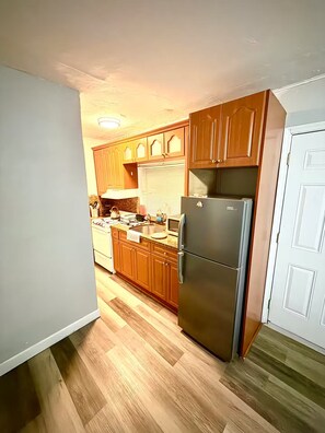 A kitchen with wooden cabinets, a stainless steel refrigerator, and a microwave. - Studio. Independent entrance, AC, internet. (Miami)