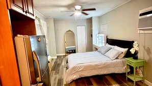 A bedroom with a bed, a ceiling fan, a dresser, and a refrigerator. - Studio. Independent entrance, AC, internet. (Miami)