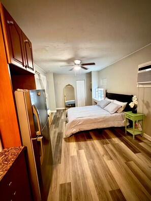 A bedroom with a bed, a ceiling fan, a dresser, and a refrigerator. - Studio. Independent entrance, AC, internet. (Miami)
