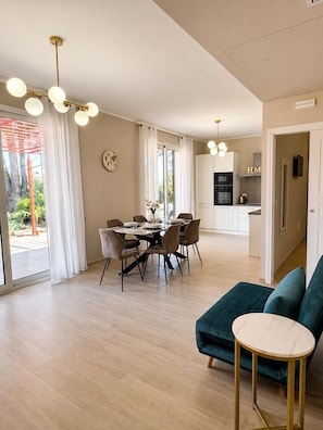 A modern living space with a dining area, a kitchen, and a seating area with a sofa and a side table. - Relaxation, comfort, and nature, with on-site parking and a terrace, just 5 minutes from the beach. (Trappitello)