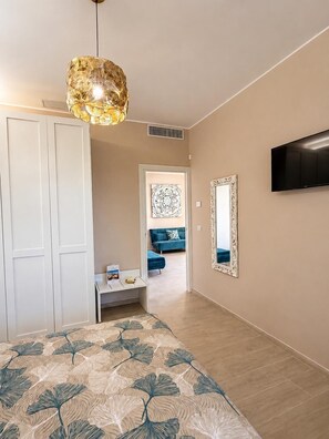 A bedroom with a bed, a wardrobe, a desk, a mirror, a television, and a hallway leading to a living area. - Relaxation, comfort, and nature, with on-site parking and a terrace, just 5 minutes from the beach. (Trappitello)