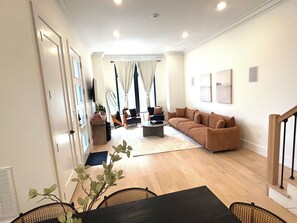 Un saló espaiós amb un sofà, una taula de centre i una zona de menjador amb cadires.