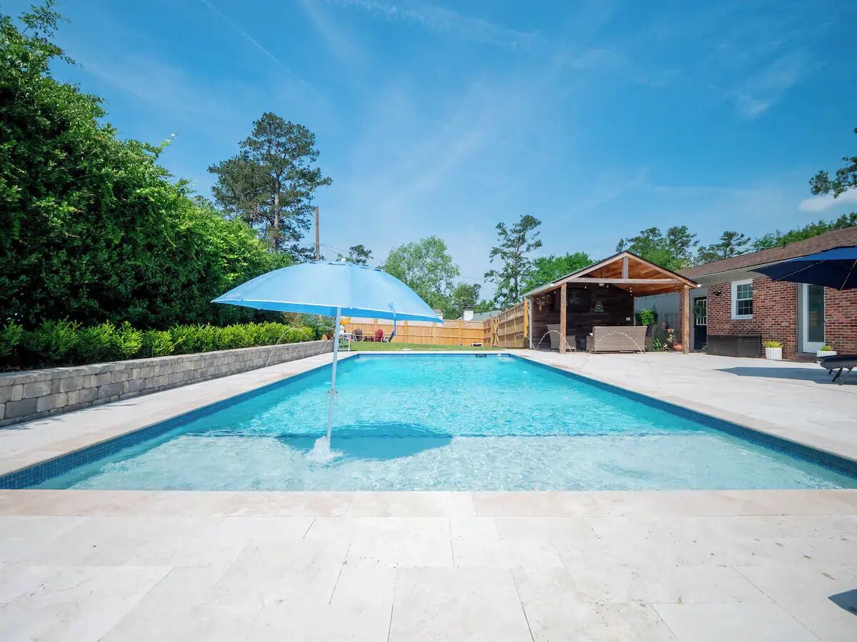 Une piscine rectangulaire à l’eau d’un bleu limpide, entourée d’une terrasse dallée.