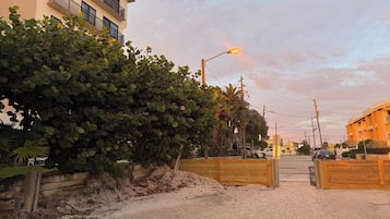 A street view with a building, a wooden fence, and a streetlight.