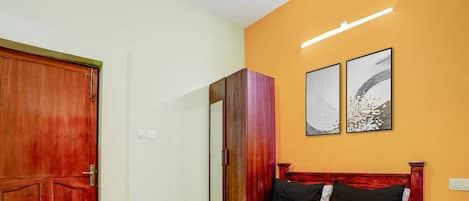 Une chambre d’hôtel comprenant un lit, une armoire et deux œuvres d’art accrochées au mur.