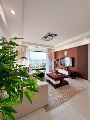 A modern living room with a large window, a flat-screen TV, a coffee table, and a sofa. - Cozy 2-bedroom apartment with AC in fantastic Nairobi (Nairobi)