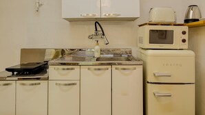 A kitchenette with a stove, microwave, and a coffee maker. - Jamil station 10 mind. 9 line subway station. Lottery world tower (Seoul)