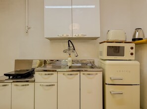 A kitchenette with a stove, microwave, and a coffee maker. - Jamil station 10 mind. 9 line subway station. Lottery world tower (Seoul)