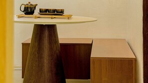A room with a round table, a wooden bench, and a hanging lamp. - Jamil station 10 mind. 9 line subway station. Lottery world tower (Seoul)