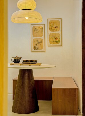 A room with a round table, a wooden bench, and a hanging lamp. - Jamil station 10 mind. 9 line subway station. Lottery world tower (Seoul)