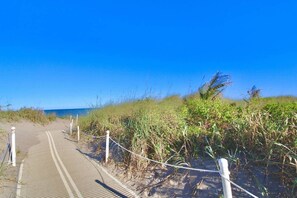 A sandy beach path leading to the ocean, surrounded by vegetation. - Seabreeze - Beautiful Newly Renovated 2 Bed Condo - Oceanfront Community - Golf Course - Resort Pool (Fort Pierce)