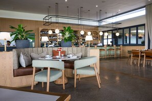 A modern restaurant interior with a bar area, seating arrangements, and a view of the outside. - Gorgeous Ocean Club Studio G21 (Durban)