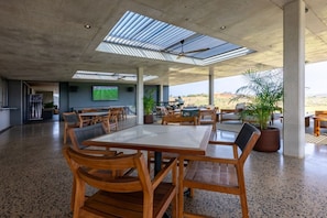 A spacious indoor area with a high ceiling, large windows, and a flat-screen TV mounted on the wall. - Gorgeous Ocean Club Studio G21 (Durban)