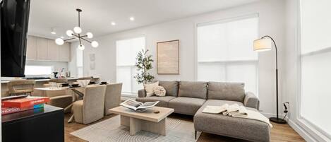 A modern living room with a sofa, coffee table, and a television.