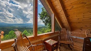 A wooden cabin with a view of a mountainous landscape through large windows. - Breathtaking Mountain Views Private Hot Tub Romantic Log Cabin Near Pigeon Forge (Sevierville)
