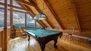Ein Billardtisch in einem Holzraum mit Blick auf die Berge.