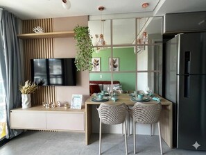 Eine moderne Küche mit integriertem Kühlschrank, einem Holzes Esstisch und zwei Korbst ühlen.