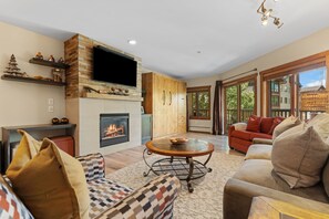 A modern living room with a fireplace, a flat-screen TV, and a cozy seating area. - Scenic Mountain Sanctuary Steps from Keystone Gondola (Keystone)