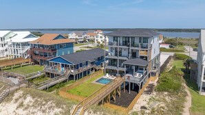 Ein Küstenwohngebiet mit mehreren Häusern, einem Schwimmbad und einem Weg zum Strand.
