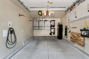 A garage with a workbench, cabinets, and a charging station. - Heavenly Tahoe Escape: EV Charger, BBQ, Balcony (South Lake Tahoe)