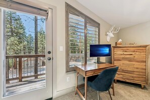 Ein Zimmer mit Schreibtisch, Stuhl, Computer und Dekoration mit einem Hirschkopf.