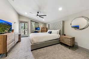 A bedroom with a bed, a desk, a television, a ceiling fan, and a large mirror. - Heavenly Tahoe Escape: EV Charger, BBQ, Balcony (South Lake Tahoe)