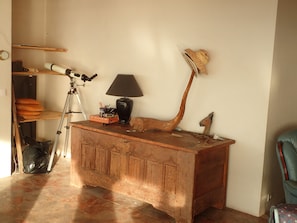 A wooden desk with a lamp, a telescope, and a decorative horn. - Charming 2-bedroom house  face the sea,  magical stay in calm nature (Champeaux)