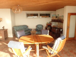 Un salon chaleureux avec une table à manger en bois, deux canapés et une cheminée.